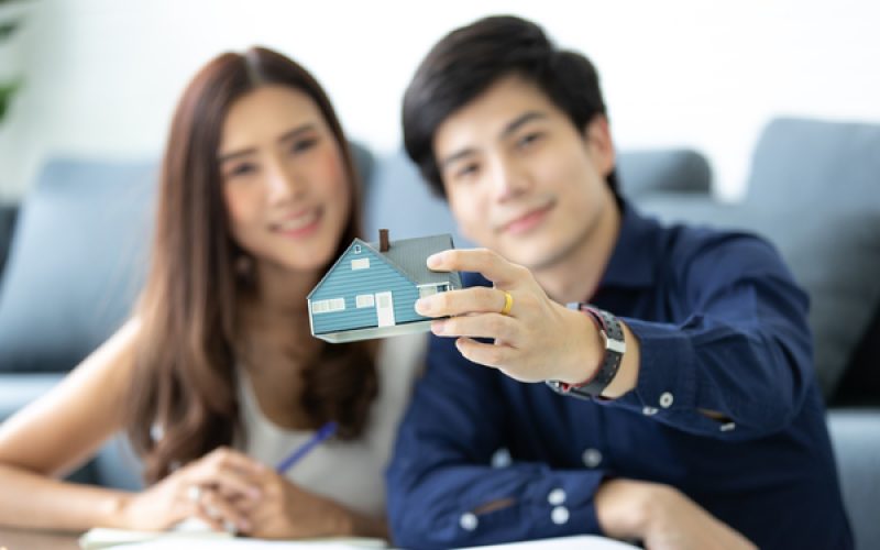 Asian teenage couple is planning to build his future house with his wife in a modern apartment.